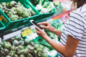 woman scanning produce with phone at grocery store