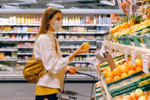 woman grocery shopping with mask